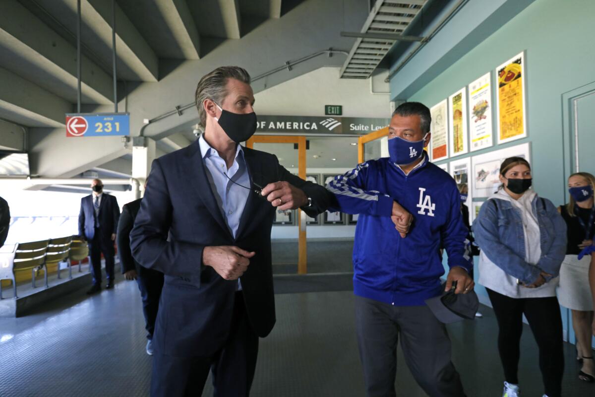 Gov. Gavin Newsom, left, visits Dodger Stadium with Secretary of State Alex Padilla on Oct. 30, 2020.