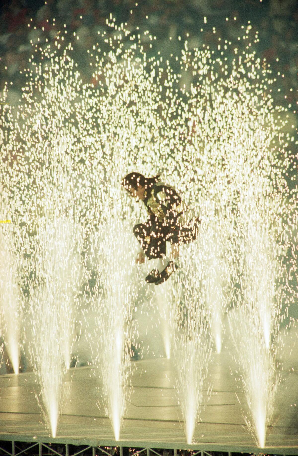 Michael Jackson leaps among the pyrotechnics during the halftime show at Super Bowl XXVII.