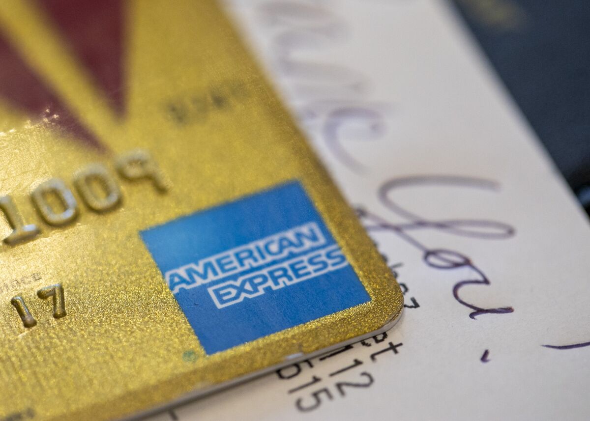 FILE - This Aug. 11, 2019, file photo shows an American Express credit card in New Orleans. American Express’ profits fell 14% in the second quarter, the company said Friday, July 22, 2022, as higher expenses more than offset record spending on its network by its cardmembers. (AP Photo/Jenny Kane, File)