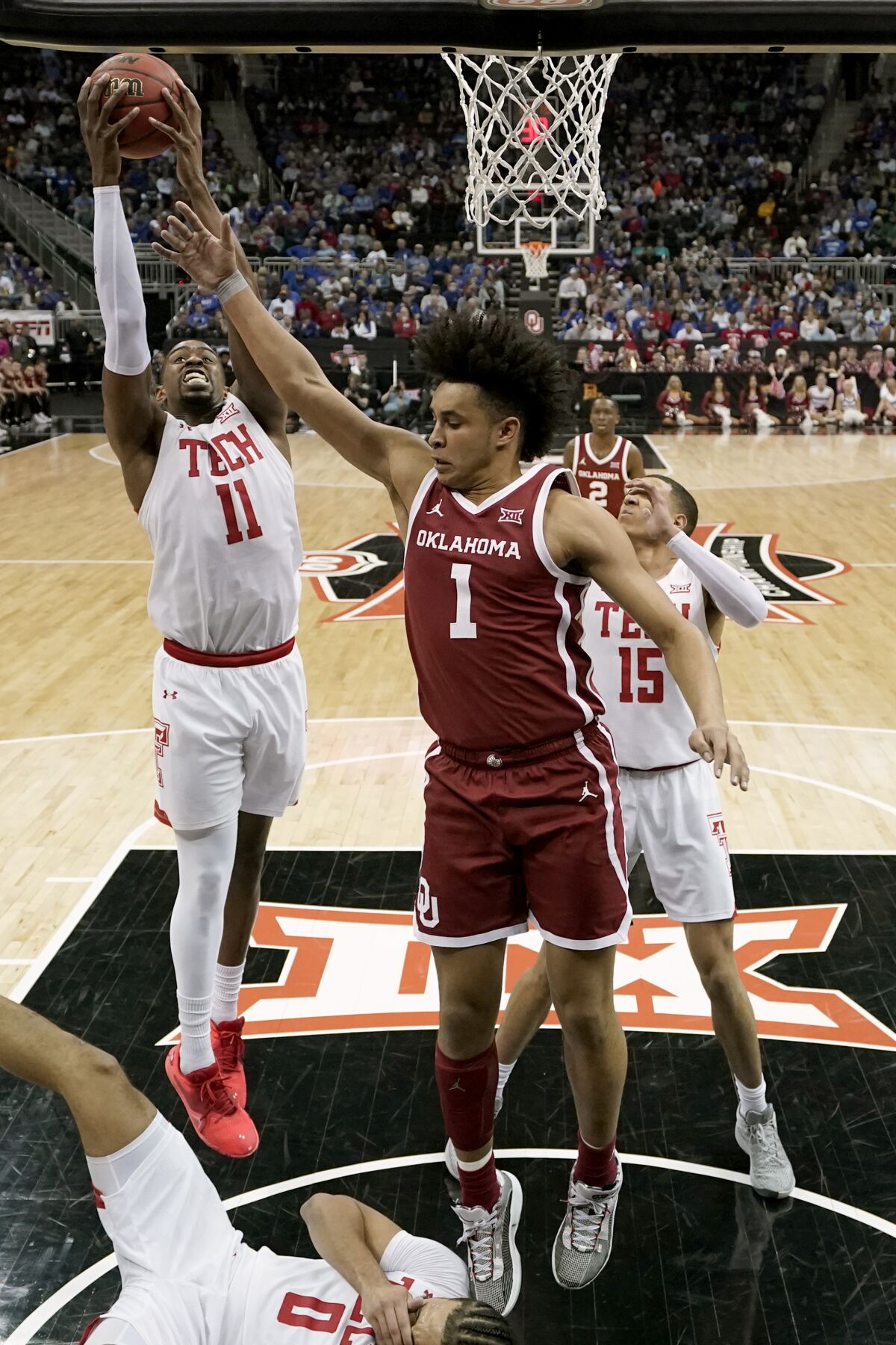 Texas Tech forward Bryson Williams (11) beats Oklahoma forward Jalen Hill (1) to a rebound during the first half of an NCAA college basketball game in the semifinal round of the Big 12 Conference tournament in Kansas City, Mo., Friday, March 11, 2022. (AP Photo/Charlie Riedel)
