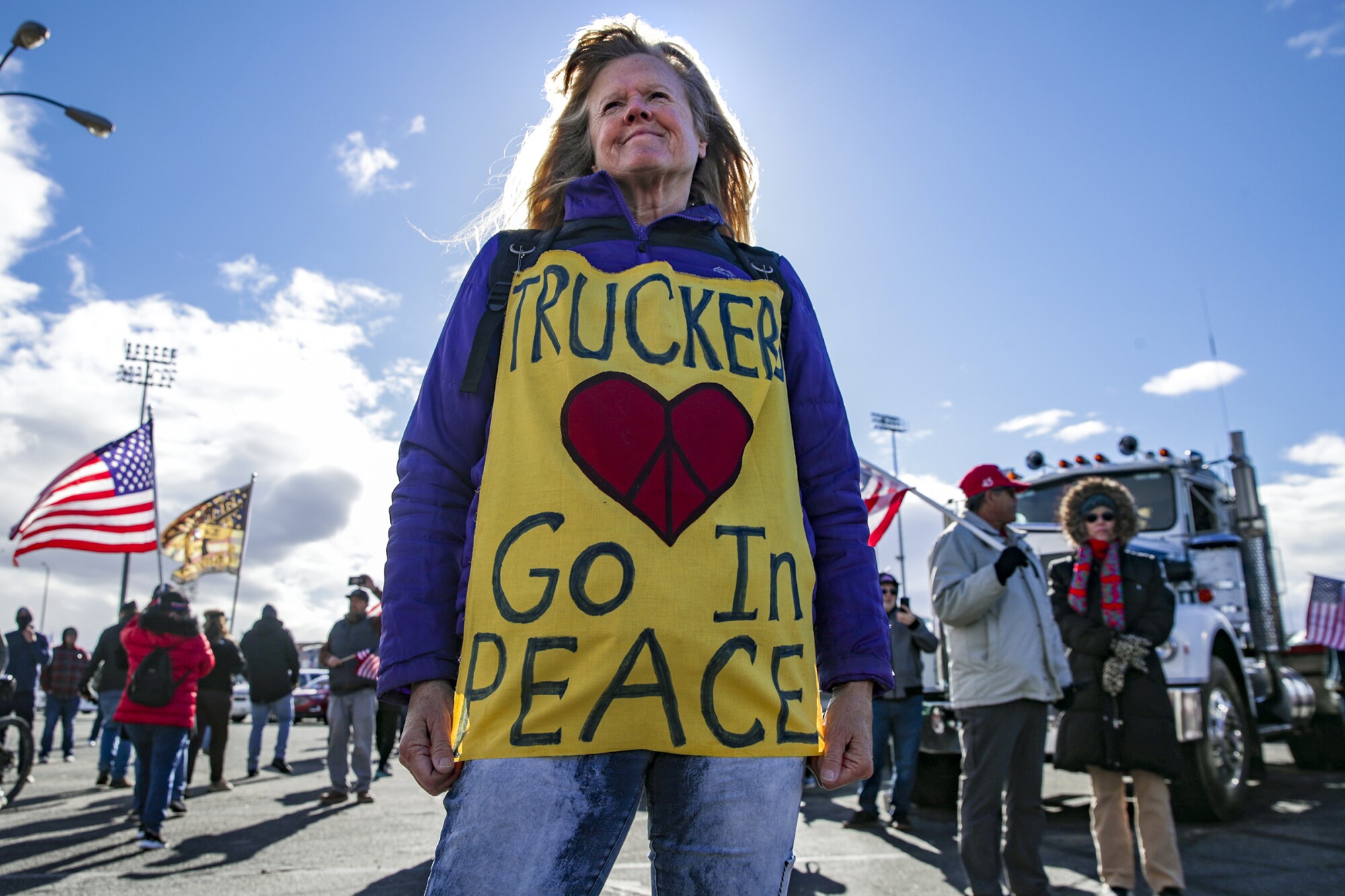 A person wears a sign reading "Truckers, go in peace" 