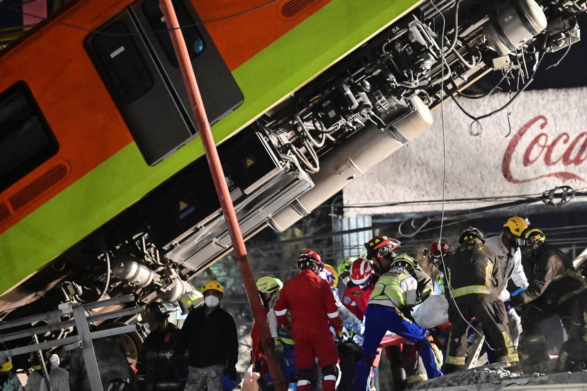 Rescue workers remove a body from a train carriage near a fallen Metro car.