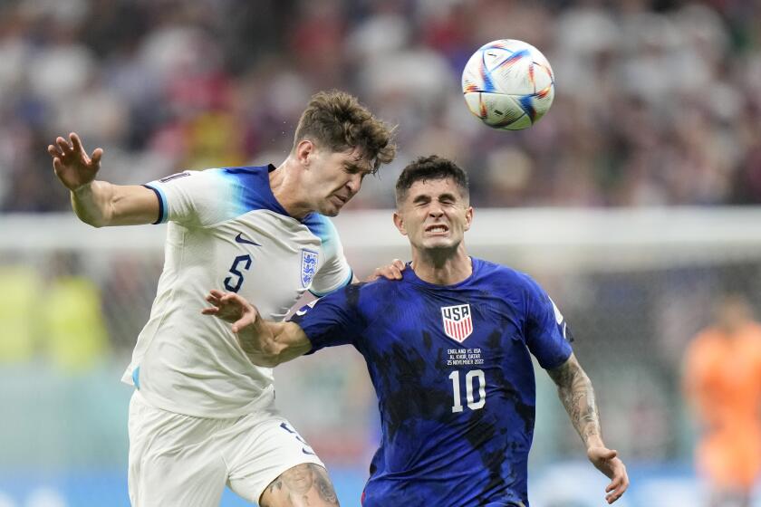 The United States' Christian Pulisic, right, vies with England's John Stones for the ball in a World Cup match Nov. 25, 2022.