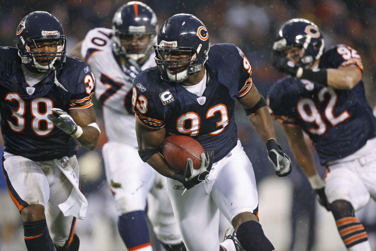 FILE - Chicago Bears' Adewale Ogunleye, accompanied by Danieal Manning (38) and Hunter Hillenmeyer (92), runs after recovering a Denver Broncos fumble during the second quarter of an NFL football game Nov. 25, 2007, in Chicago. Ogunleye, a Pro Bowl defensive end during a 10-year career, leads UBS Global Wealth Management’s athletes and entertainers strategic client segment. (AP Photo/Nam Y. Huh, File)