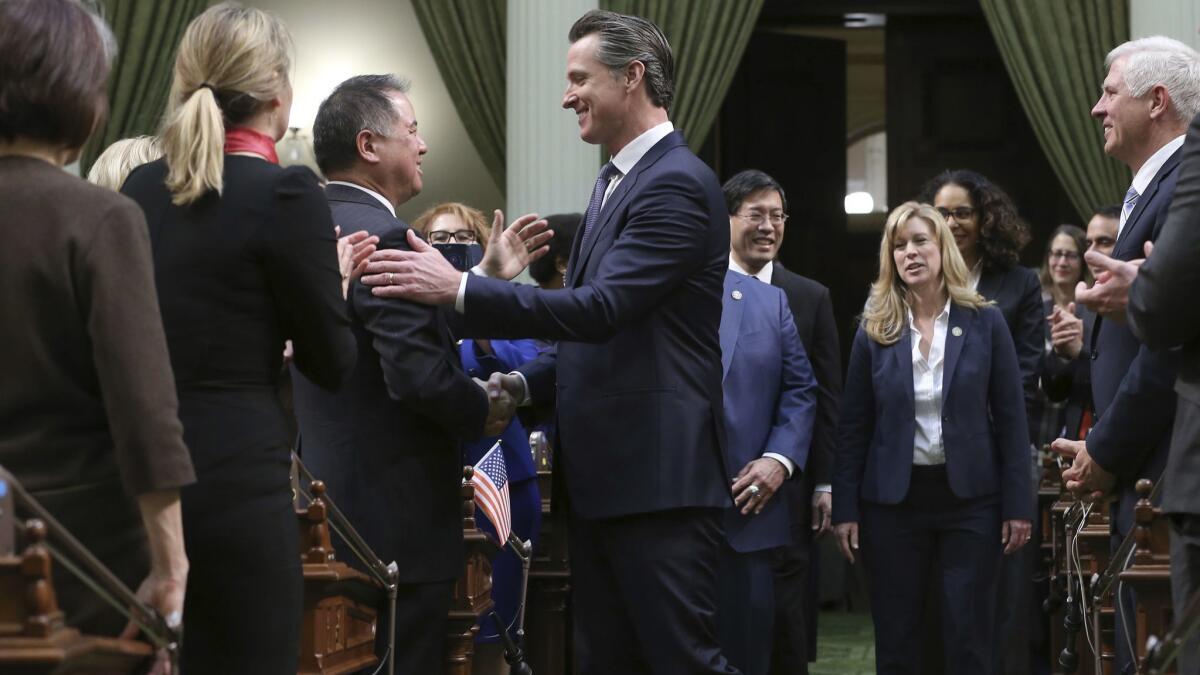 California Gov. Gavin Newsom, center, shakes hands with Assemblyman Phil Ting (D-San Francisco) as he enters the Assembly chambers to deliver his State of the State address in February.