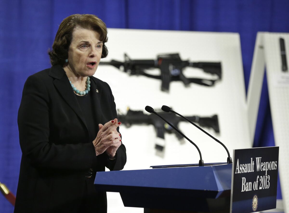 La sénatrice Dianne Feinstein prend la parole en 2013 devant des illustrations d'armes d'assaut.