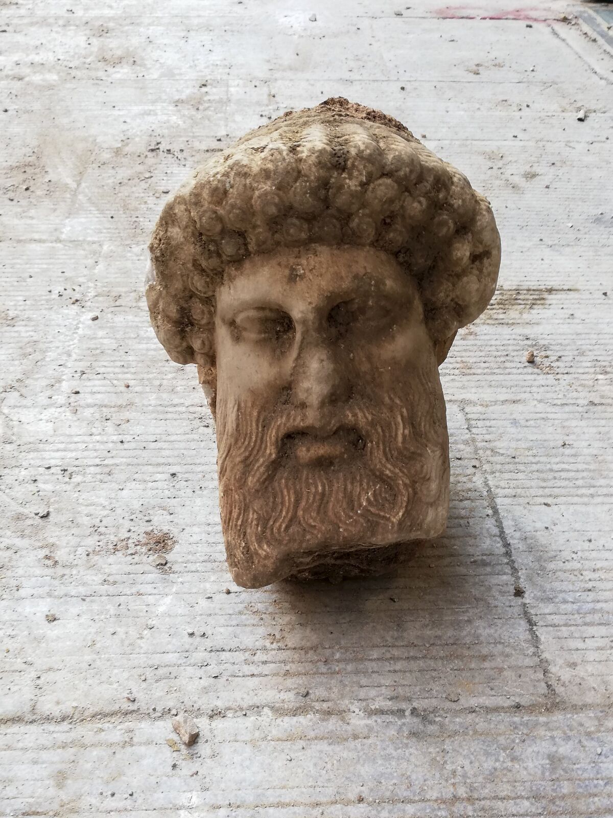 In this undated photo, provided by the Greek Culture Ministry on Sunday, Nov. 15, 2020, a head of the ancient god Hermes is pictured after being found during sewage works in central Athens. The ministry said Sunday that the head, depicting Hermes at a "mature age", one of many that served as street markers in ancient Athens, appears to be from around 300 BC, that is, either from the late 4th century BC, or the early 3rd century. (Greek Culture Ministry via AP)