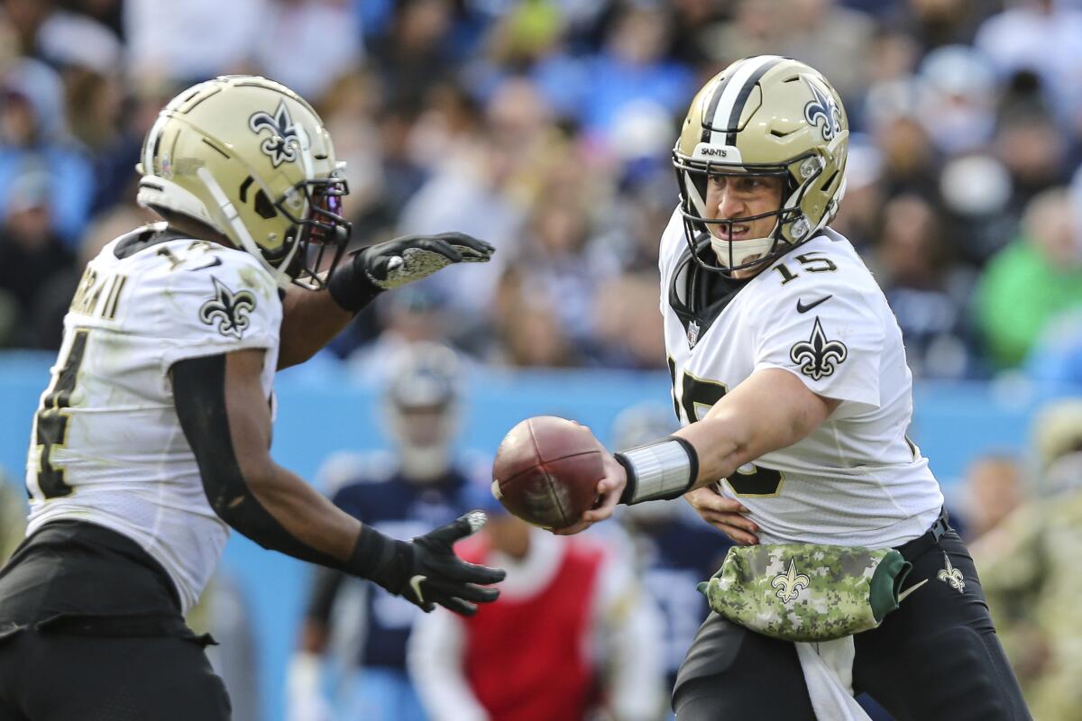 New Orleans Saints quarterback Trevor Siemian looks to hand off the ball.