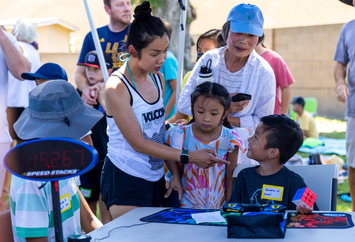 Orchid Nguyen congratulates her son, Hendrix Nguyen, on his 19-second solve during the Rubik's Cube speed-cubing competition.
