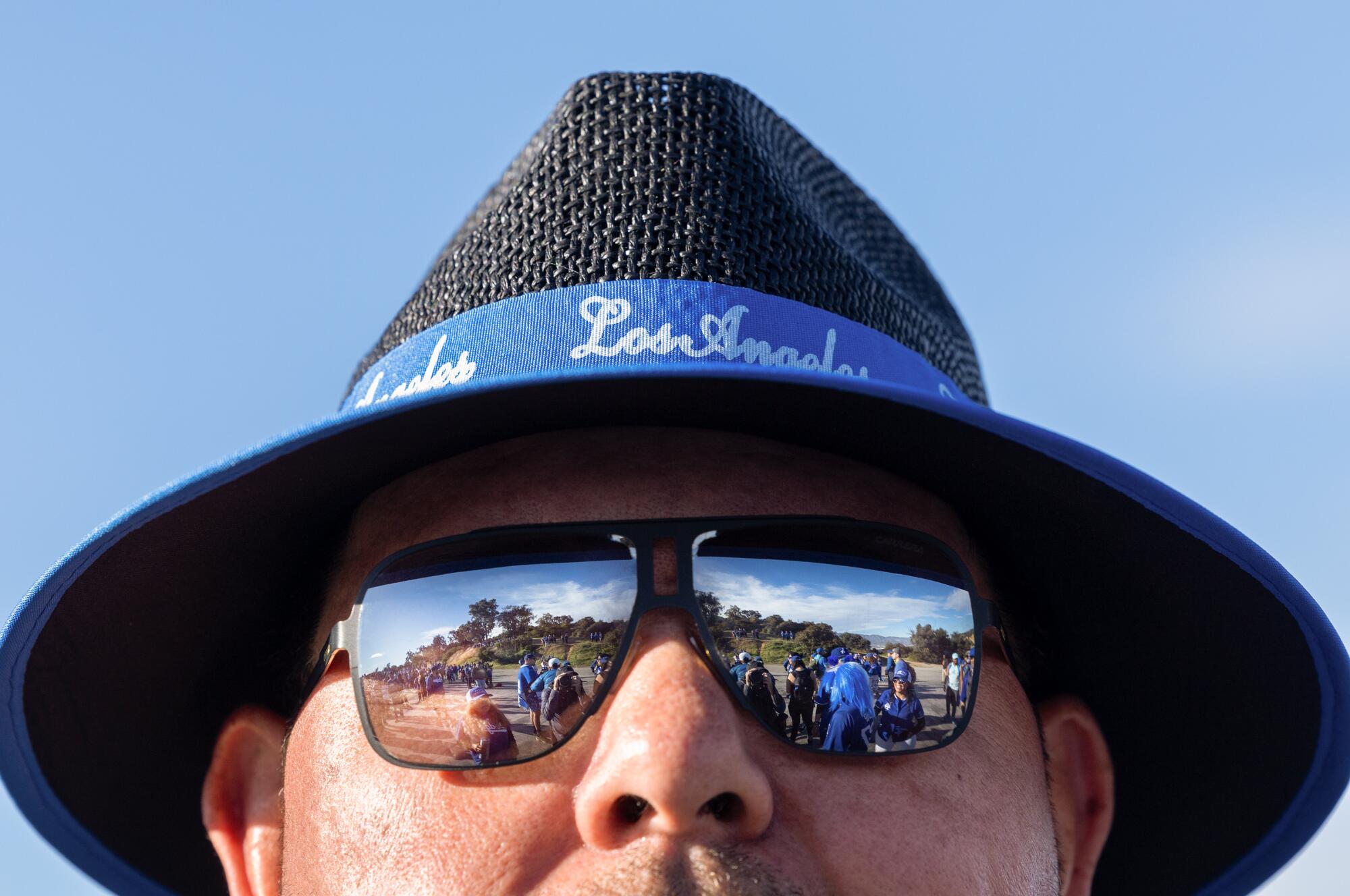 Hikers are reflected in Dodger fan Juan Peregrina's sunglasses.