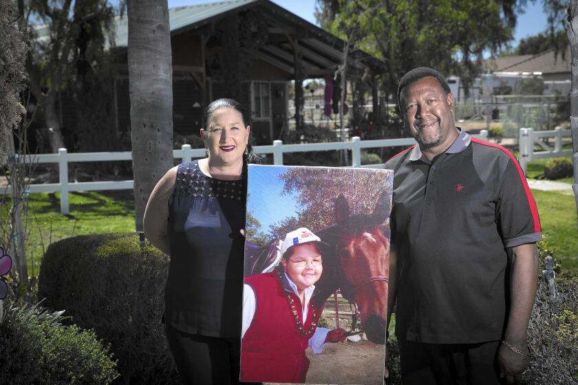 Carole and Ty Moss hold a photo of their son, Nile, who died at age 15 after he went to an Orange County hospital for an MRI and got infected with a superbug. A law giving the public access to limited data on infected patients was named after him.