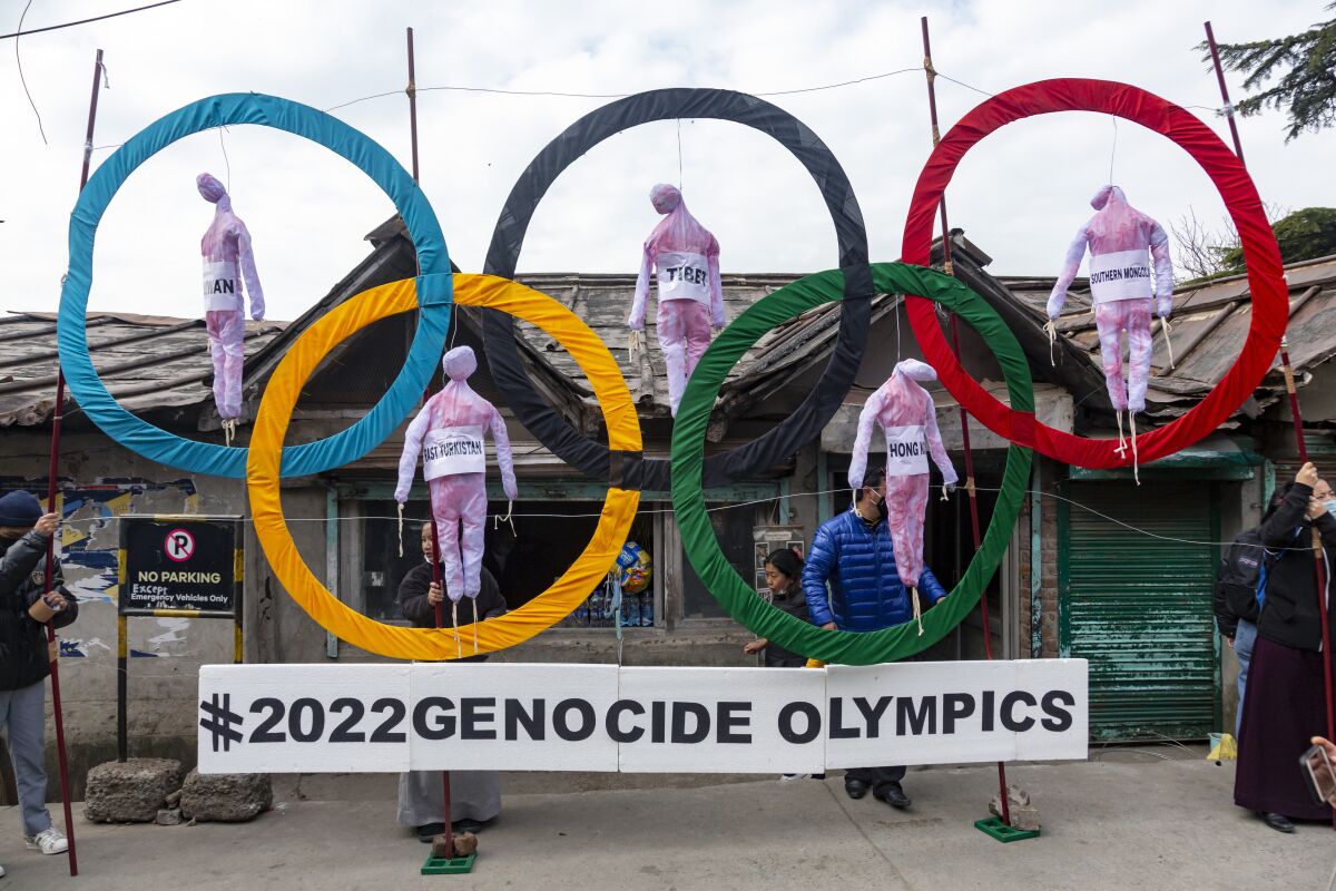 Protesters display effigies representing China's human rights abuses hanging from the Olympic rings