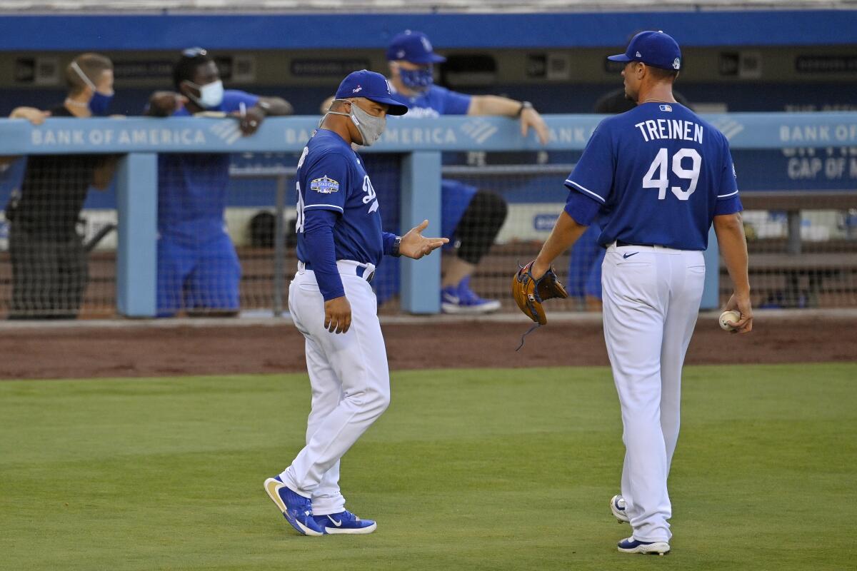 Dodgers manager Dave Roberts talks with relief pitcher Blake Treinen.