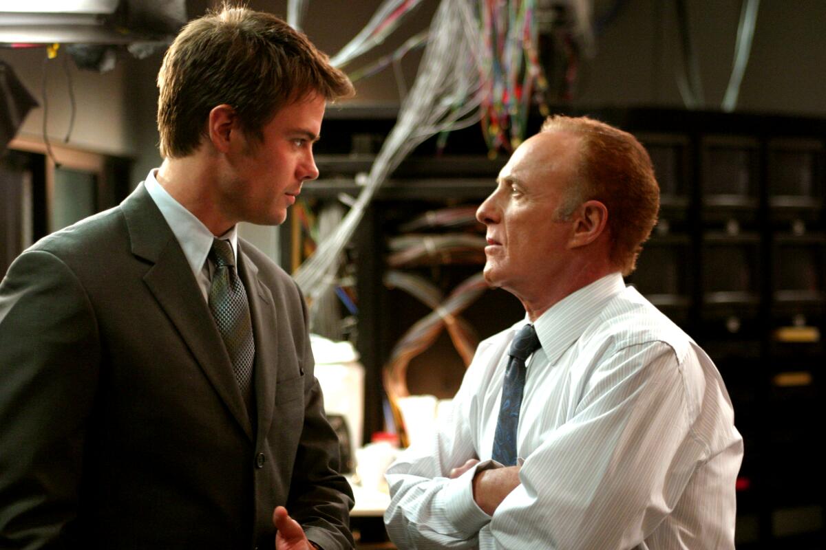 A man in a suit chats with a man in a shirt and tie in a scene from NBC's "Las Vegas."
