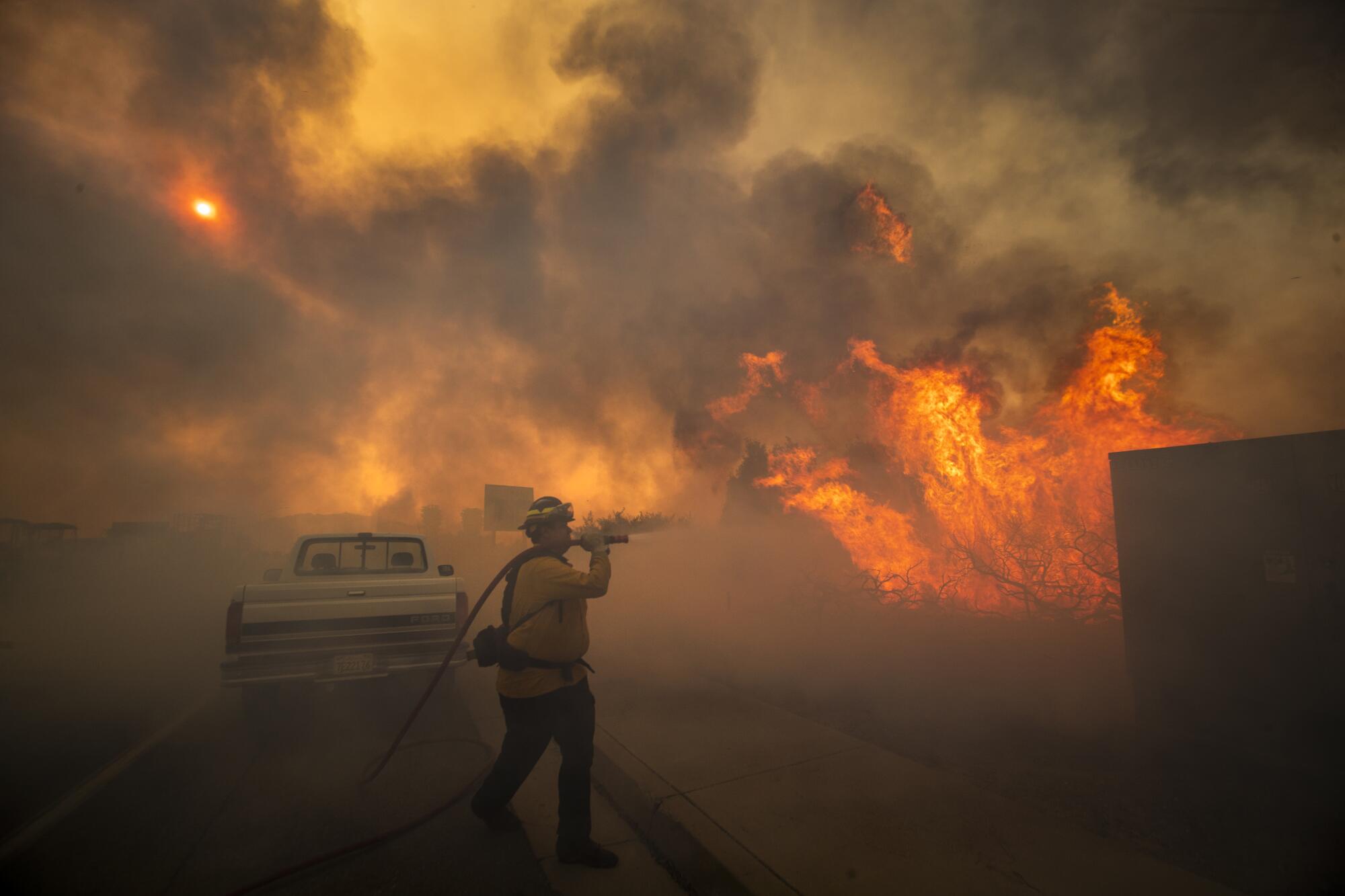 Firefighter Raymond Vasquez fights the Silverado fire fueled by Santa Ana winds at the 241 Freeway.