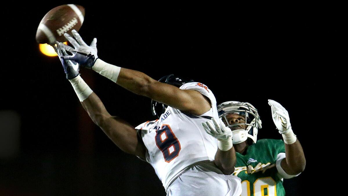 Chaminade's Jahlil Pinkett tries to haul in a pass after getting position on Long Beach Poly's Kejuan Markham during the Eagles' 50-14 win Friday night.