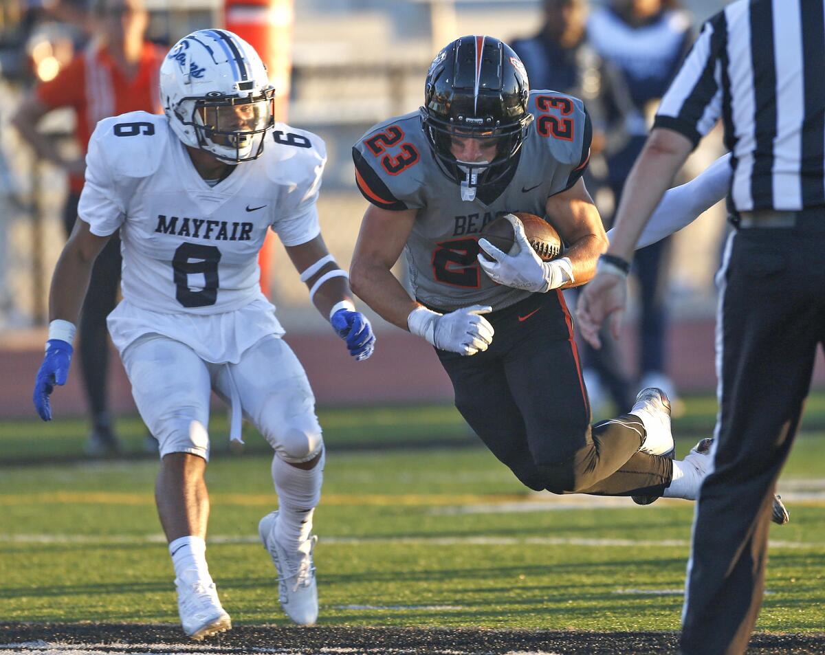 Huntington Beach running back Tyler Young (23) dives into the end zone for a touchdown against Mayfair on Friday night.