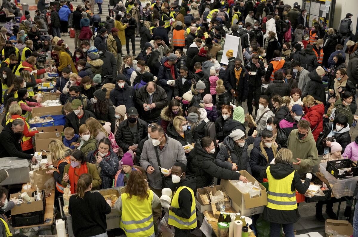 Ukrainian refugees queue for food in the welcome area after their arrival at the main train station in Berlin