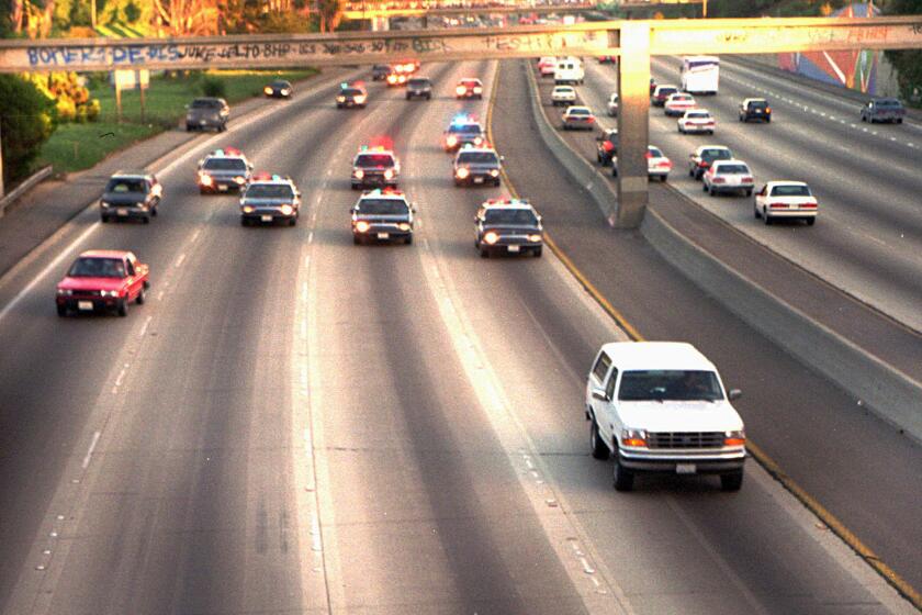 In this June 17, 1994, photo, a white Ford Bronco, driven by Al Cowlings carrying O.J. Simpson, is trailed by Los Angeles police cars as it travels on a Southern California freeway in Los Angeles.