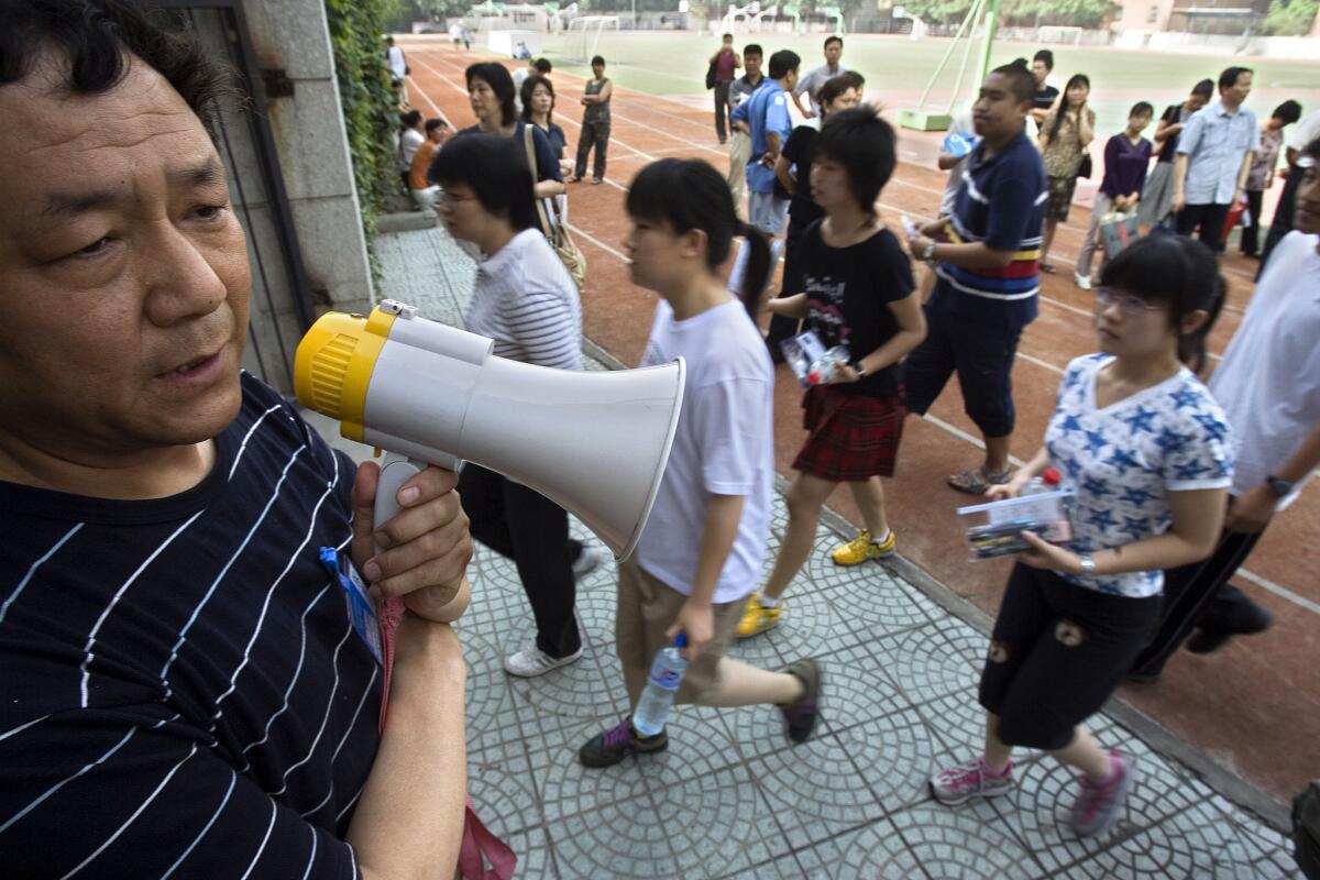 A Chinese official directs students arriving for the first day of national college entrance exams in Beijing in 2006.