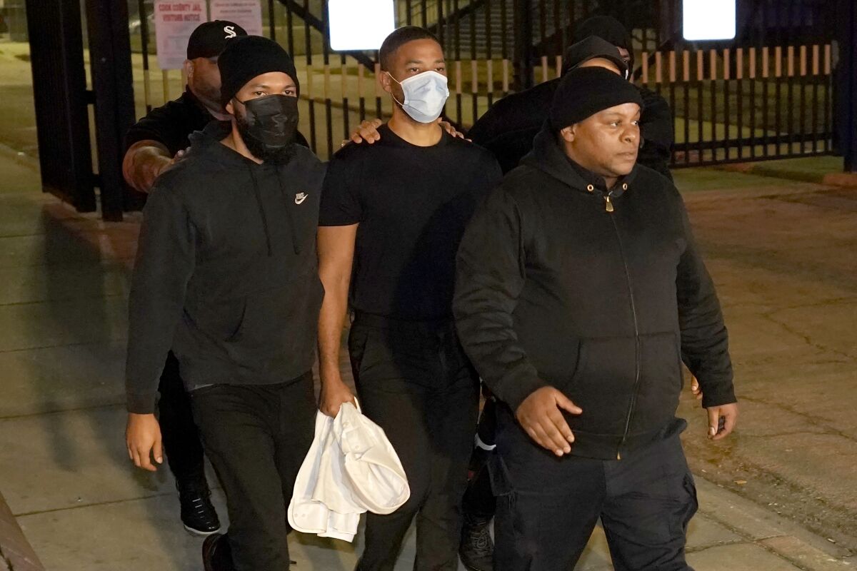 A group of men wearing black leave a jail.