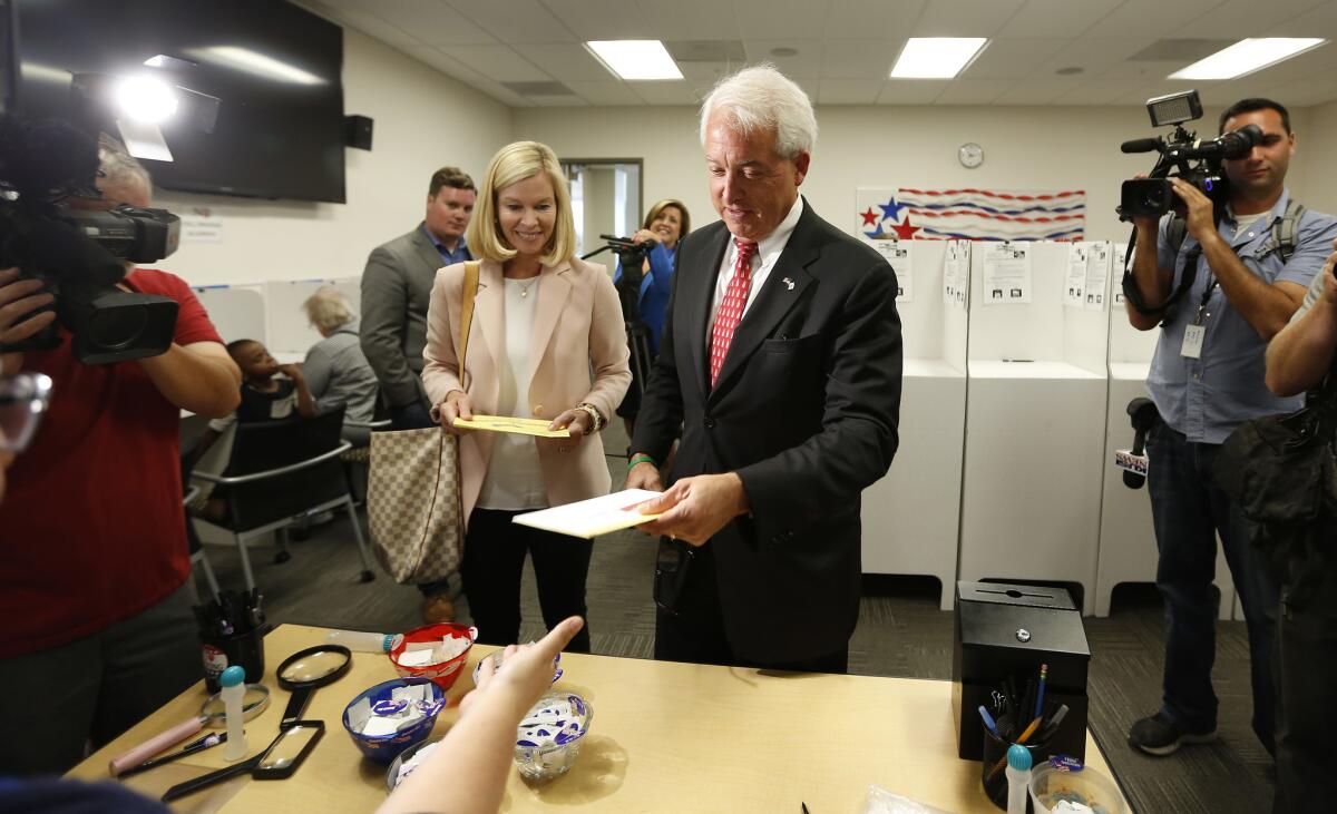 GOP gubernatorial candidate John Cox and his wife, Sarah, turn in their ballots after voting at the San Diego Registrar of Voters on Monday.