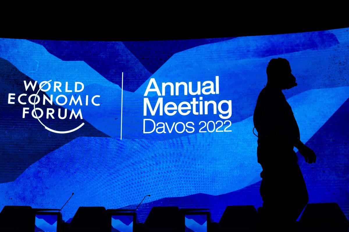 ARCHIVO - Trabajadores colocan el escenario antes de la cumbre anual del Foro Económico Mundial en Davos