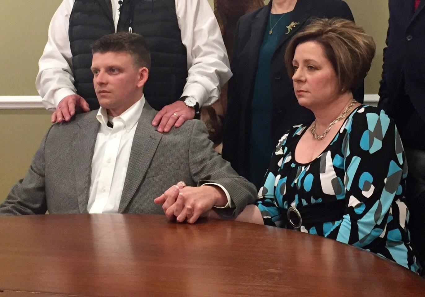 Montgomery Police Officer Aaron Smith holds hands with his mother, Kim Smith, at a news conference with attorneys Wednesday in Montgomery, Ala.