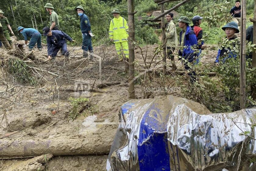 Rescue workers clear mud and debris brough down by a flood in Lang Nu hamlet in Lao Cai province, Vietnam Tuesday, Sep. 10, 2024. (Pham Hong Ninh/VNA via AP)