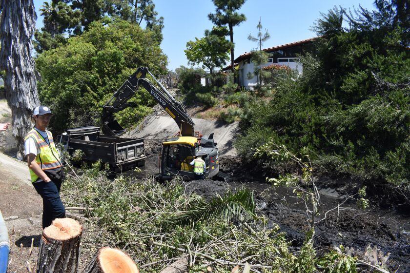 A city crew cleaning out vegetation and other debris from the Pomerado 2 Channel.