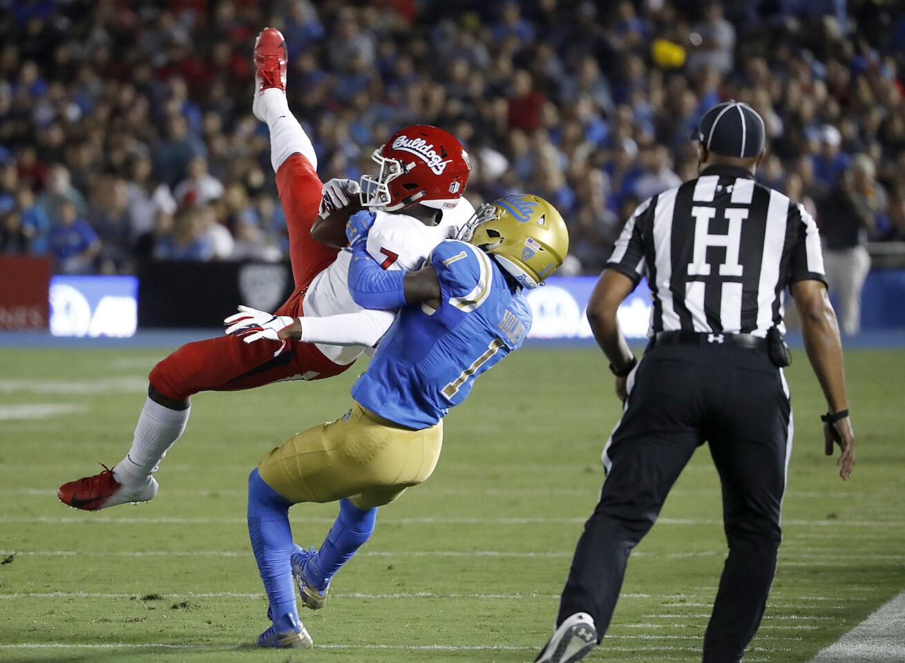 UCLA cornerback Darnay Holmes brings down Fresno State wide receiver Derrior Grim in the first quarter on Saturday.