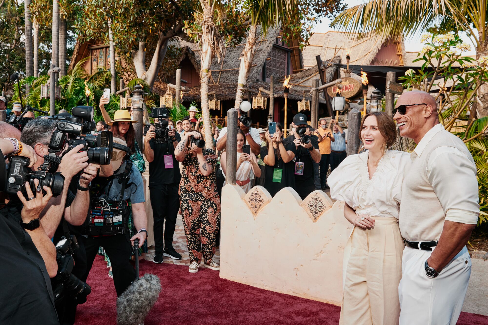 Emily Blunt and Dwayne Johnson exit the Jungle Cruise ride and stand for photographers on the red carpet.
