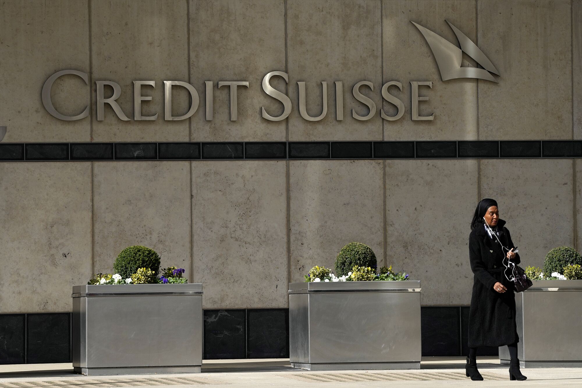 A woman walks past the Credit Suisse bank headquarters in London