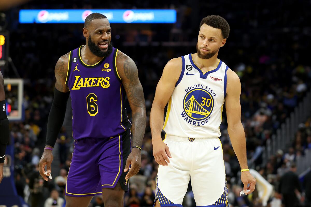 Lakers star LeBron James, left, speaks to Golden State Warriors star Stephen Curry.