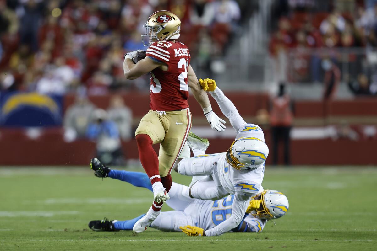 49ers running back Christian McCaffrey runs past Chargers safety Derwin James Jr. and cornerback Asante Samuel Jr.