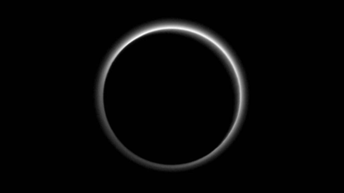 Backlit by the sun, Pluto’s atmosphere rings its silhouette like a luminous halo in this image taken by NASA’s New Horizons spacecraft around 9 p.m. Pacific time on July 15, when the spacecraft was about 1.25 million miles from the dwarf planet.