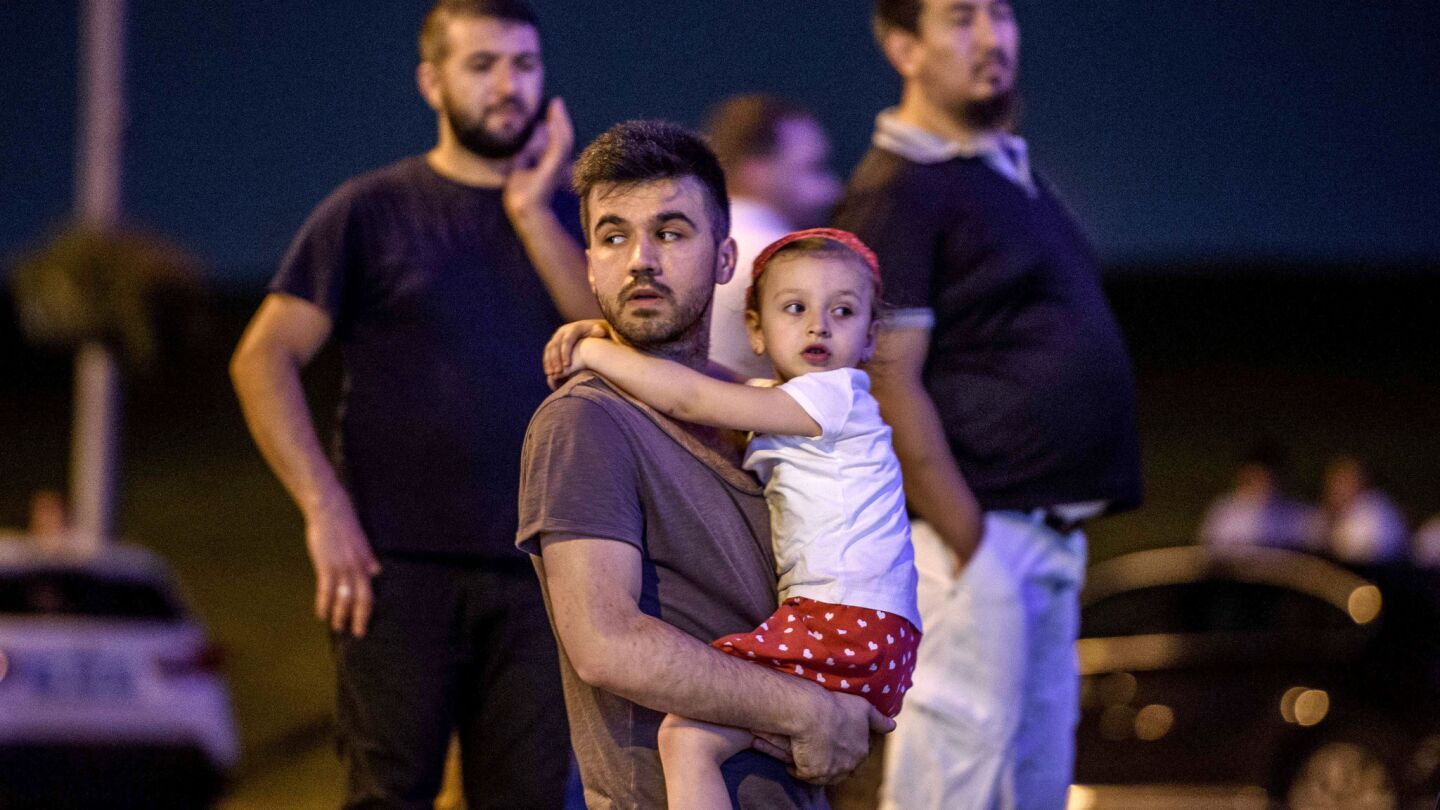 A man carries his daughter as passengers leave Ataturk Airport.