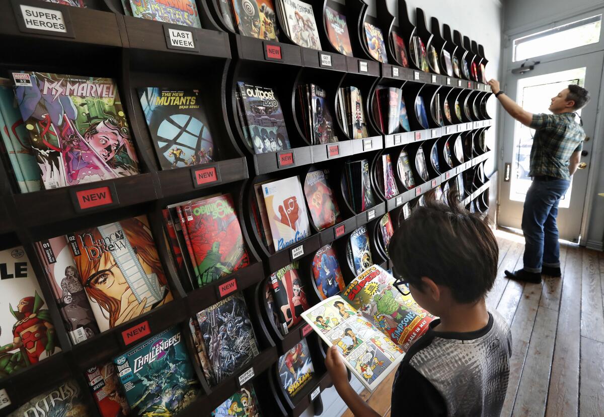 A boy looks at a comic book at Secret Headquarters.