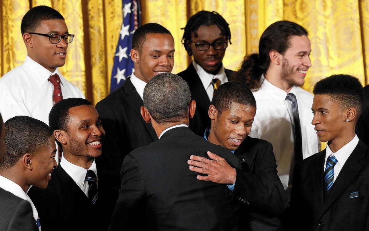 President Obama hugs guests from Chicago as he announces the My Brother's Keeper initiative, designed to help young black and Latino men.