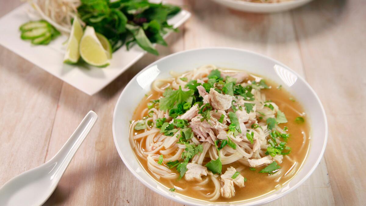 A bowl of chicken pho, with traditional additions of herbs, bean sprouts and lime