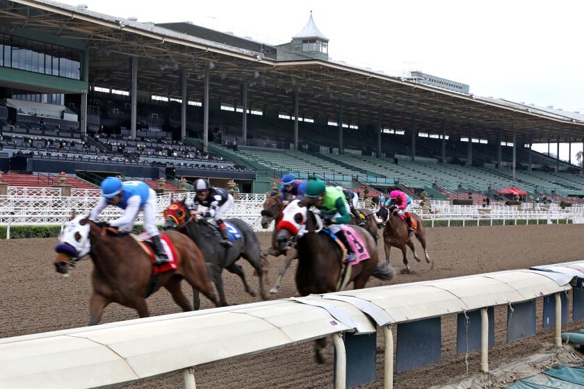ARCADIA, CALIF. -- SATURDAY, MARCH 14, 2020: Time for Suzzie, ridden by Jorge Velez, crosses the finish line in first place in the first race at Santa Anita Park in Arcadia, Calif., on March 14, 2020. The track is closed to fans due to the coronavirus, but the horses are still running. (Gary Coronado / Los Angeles Times)