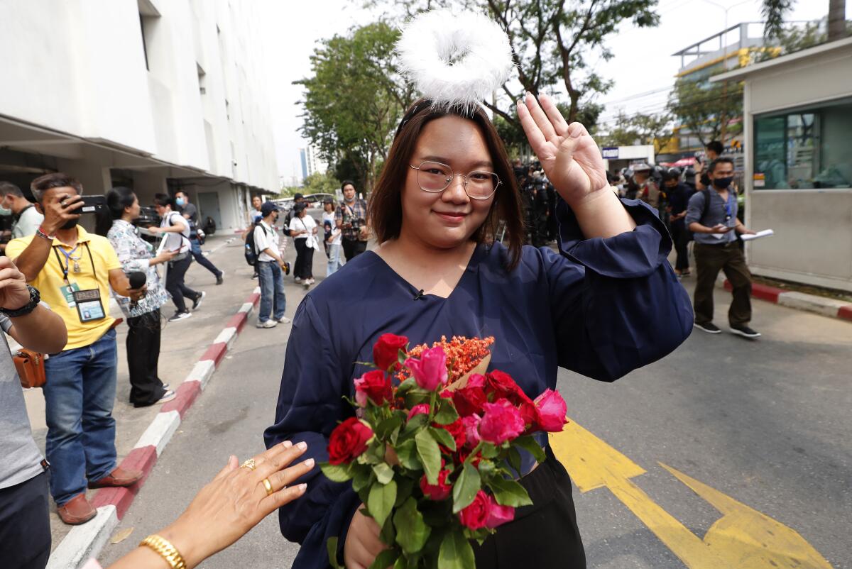 In this Monday, March 8, 2021, photo, pro-democracy activist Panusaya Sithijirawattanakul gestures with a three-fingers salute, a symbol of resistance, as she arrived at the Attorney General office in Bangkok, Thailand. Panusaya, one of the pro-democracy leaders, has been released on a THB$200,000 (USD$6,400) bail with a condition that she has to wear an electronic monitoring bracelet. (AP Photo/Sakchai Lalit)