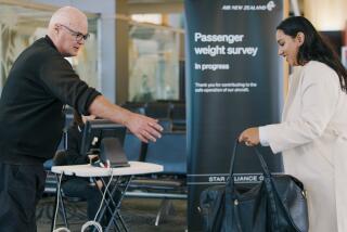 In this photo provided by Air New Zealand, a woman hands her bag to a staff member to be weighed ahead of a flight in Auckland, New Zealand, on May 29, 2023. New Zealand's national airline is asking people to step on the scales before they board international flights. Air New Zealand says it wants to weigh 10,000 passengers as part of a monthlong survey to better estimate the weight and balance of its planes. (Air New Zealand via AP)