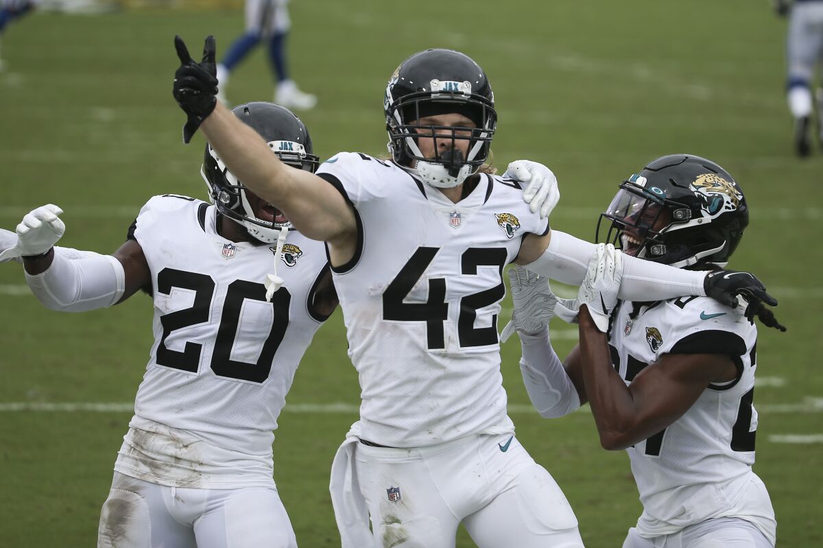 Jacksonville Jaguars safety Andrew Wingard (42) celebrates after intercepting a Indianapolis Colts pass with teammates safety Daniel Thomas (20) and Chris Chaisson, right, during the second half of an NFL football game, Sunday, Sept. 13, 2020, in Jacksonville, Fla. (AP Photo/Stephen B. Morton)