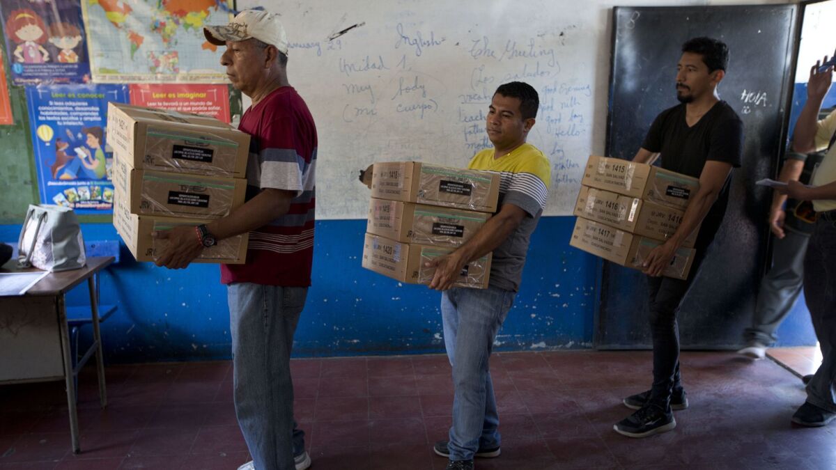 Electoral volunteers unload boxes of ballots at a polling station on the outskirts of San Salvador. Salvadorans elect a new president on Sunday.