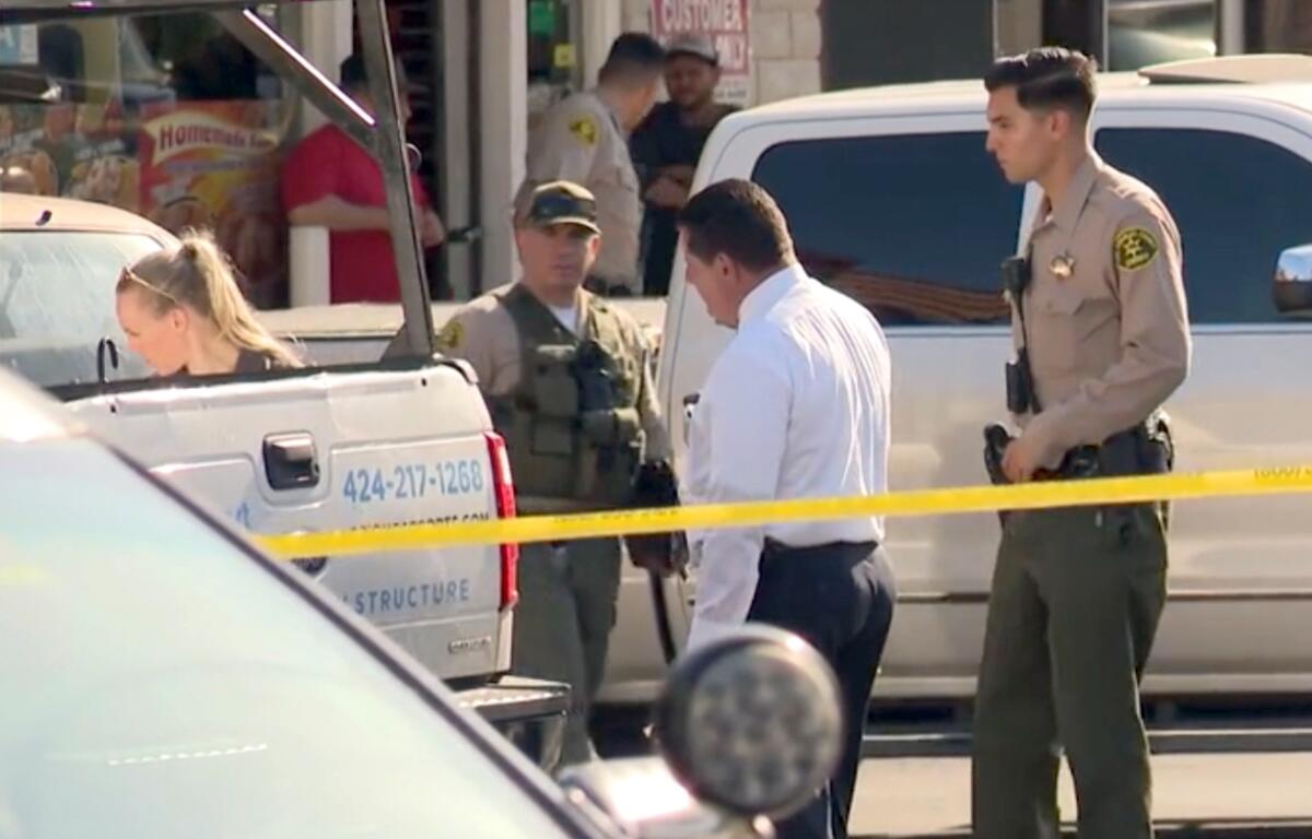 Los Angeles County sheriff's personnel at a crime scene.