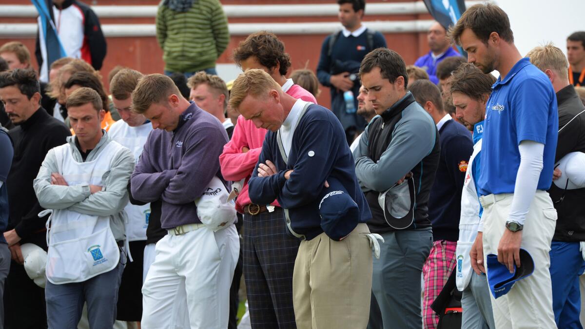 Golfers observe a moment of silence during the final round of the Madeira Islands Open following the death of caddie Ian McGregor, who died while on the course Sunday.