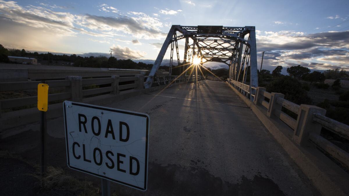 The sun sets behind the now closed Walnut Canyon Bridge. (Brian van der Brug / Los Angeles Times)
