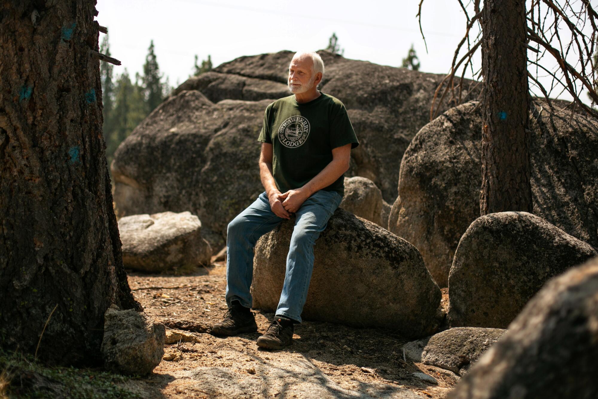  Michael Hicks sits outside on a large rock