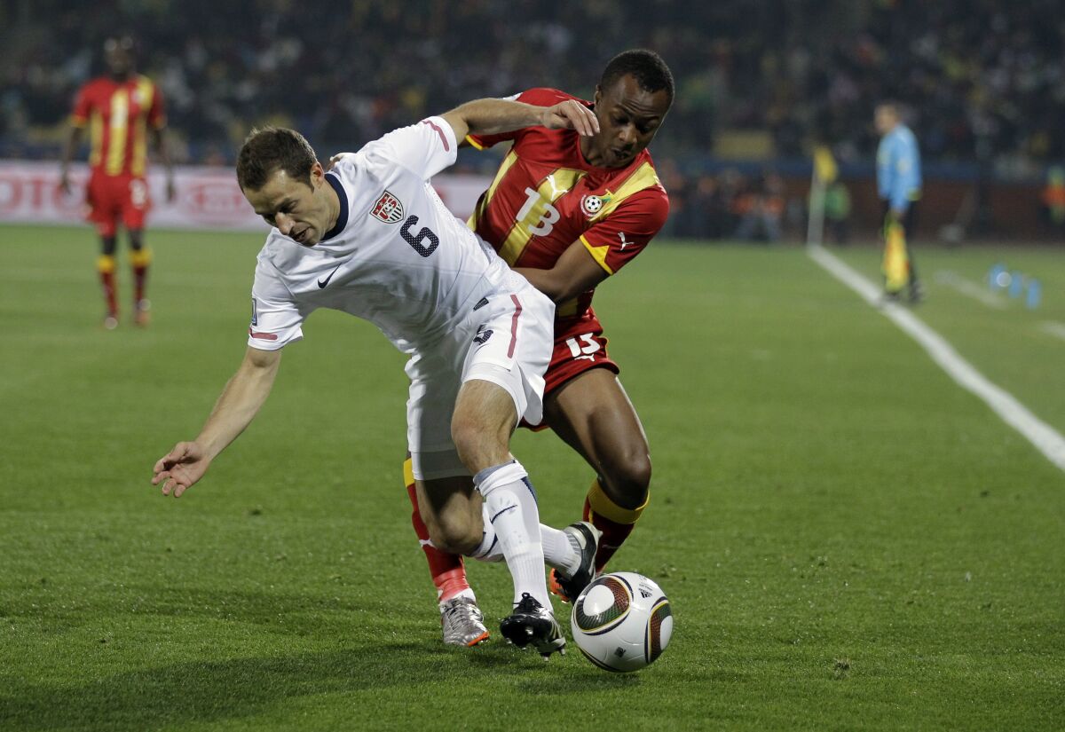 FILE - In this June 26, 2010, file photo, United States' Steve Cherundolo, left, and Ghana's Dede Ayew, right, compete for the ball during a World Cup round of 16 soccer match in Rustenburg, South Africa. American national team defenders Cherundolo and Christie Pearce have been elected to the U.S. National Soccer Hall of Fame. (AP Photo/Matt Dunham, File)